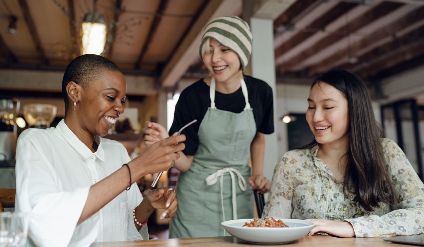 A hospitality professional sharing a warm moment with café guests